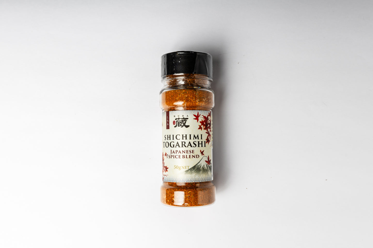 A bottle of Shichimi Togarashi Japanese Spice Blend with a black cap and a white label featuring red and black text, set against a plain white background.