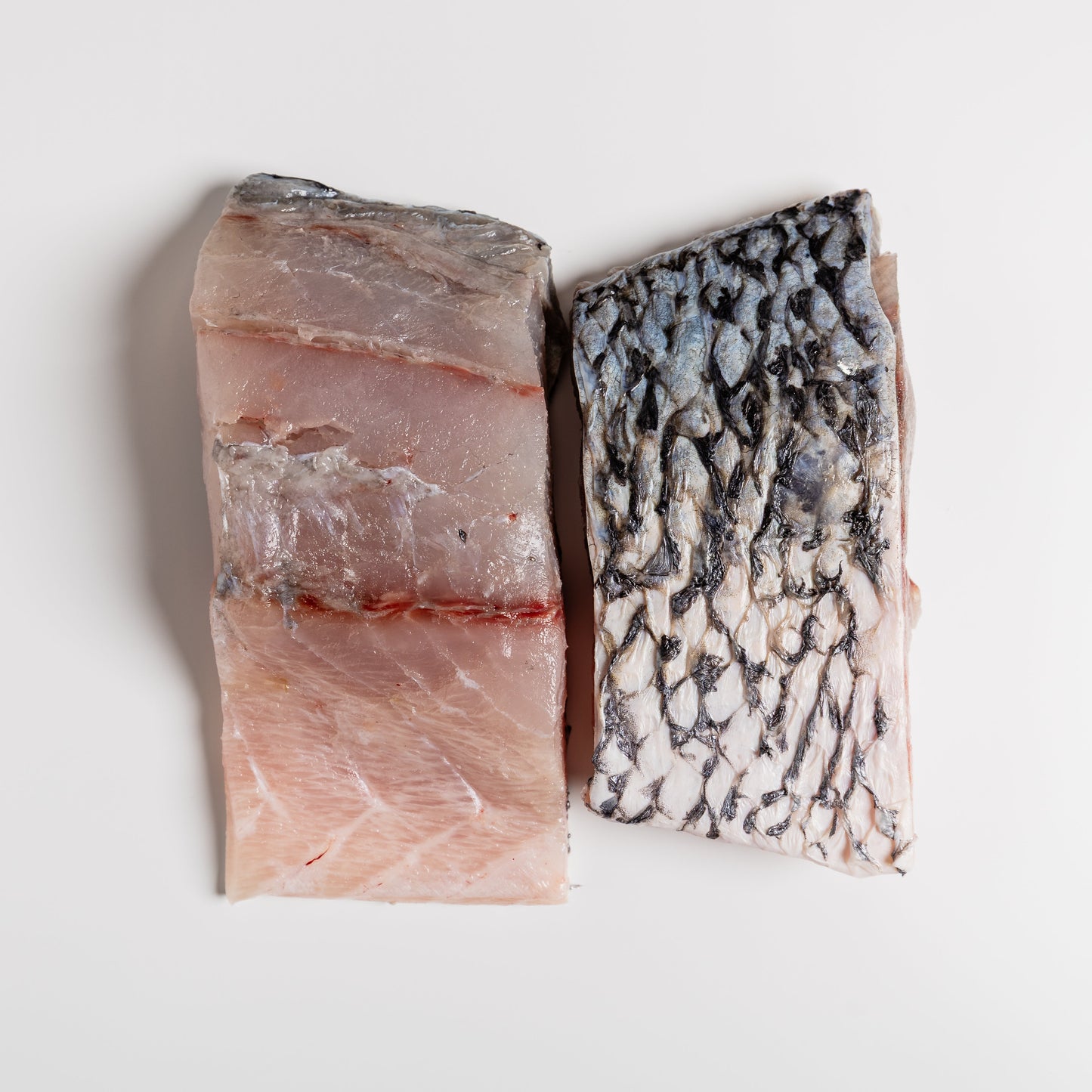 
                  
                    Two pieces of barramundi fish fillets on a white background
                  
                